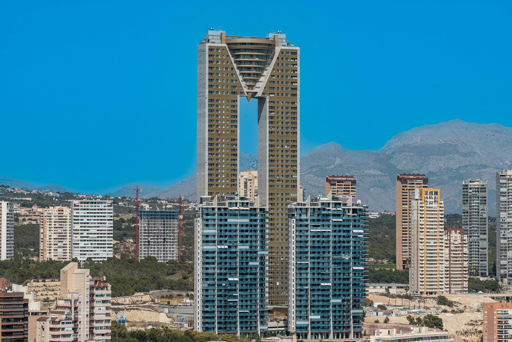 Exterior of the gold-clad Intempo building, a premier Intempo building investment opportunity on Poniente beach.